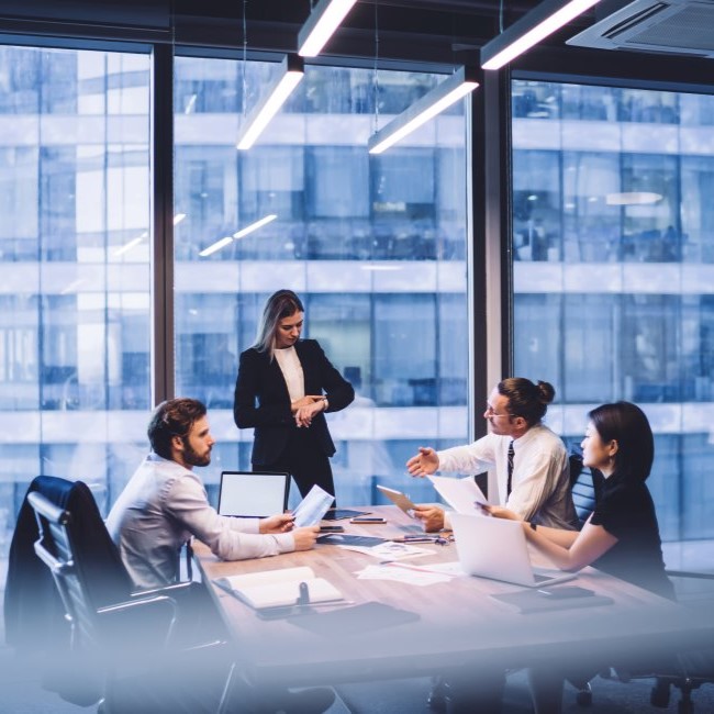 A group of investors sitting at an office table conversing