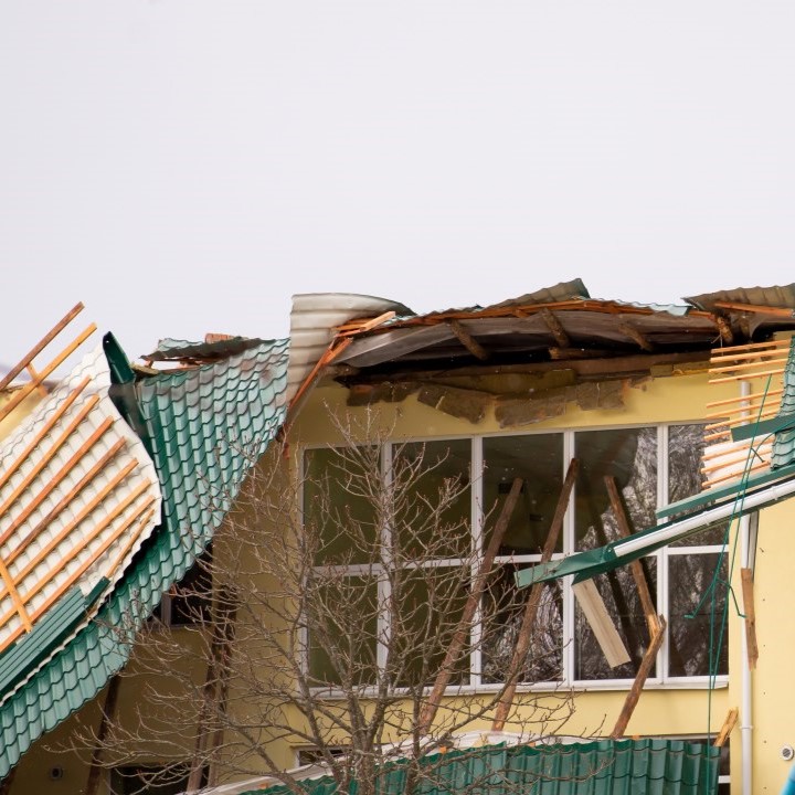 View of a building with wind damaged shingles