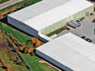 Bird's-eye view of two commercial warehouses with a white roof