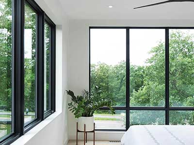 Large modern bedroom with black framed Pella windows