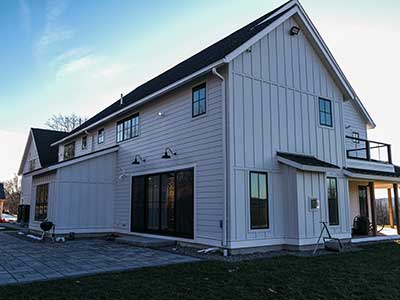 Side view of a large home with white James Hardie siding installed