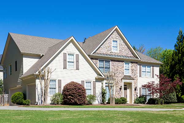 Typical mid-class, white home with a light brown shingle roof