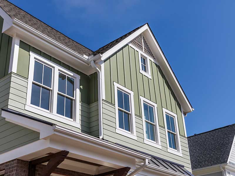 Large two-story, mid-class residential home with green siding