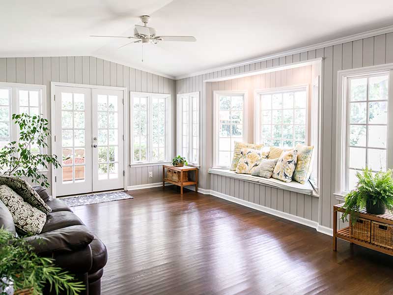 Living room area filled with natural light coming in from the large windows around it